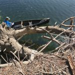 Sungnome in a canoe documenting bathymetric survey data